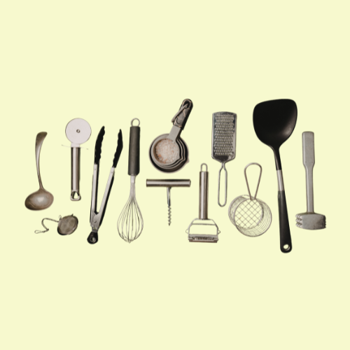 Variedad de utensilios para manipulación de alimentos de acero inoxidable y silicona sobre fondo amarillo.