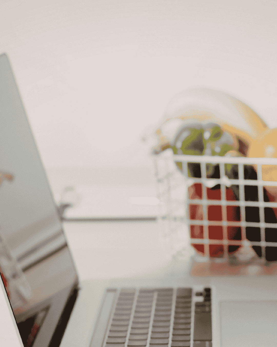 Portátil junto a cesta de frutas para realizar el curso de manipulador de alimentos online.